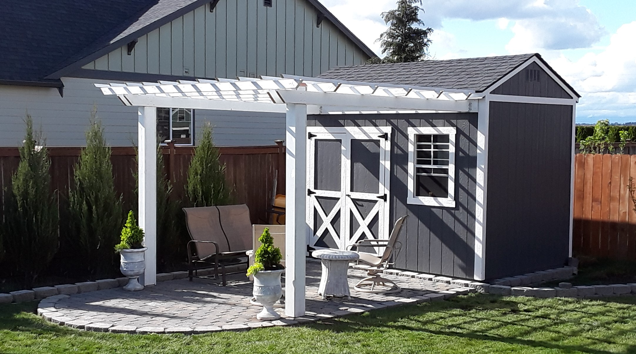 Garden shed with patio for a backyard.