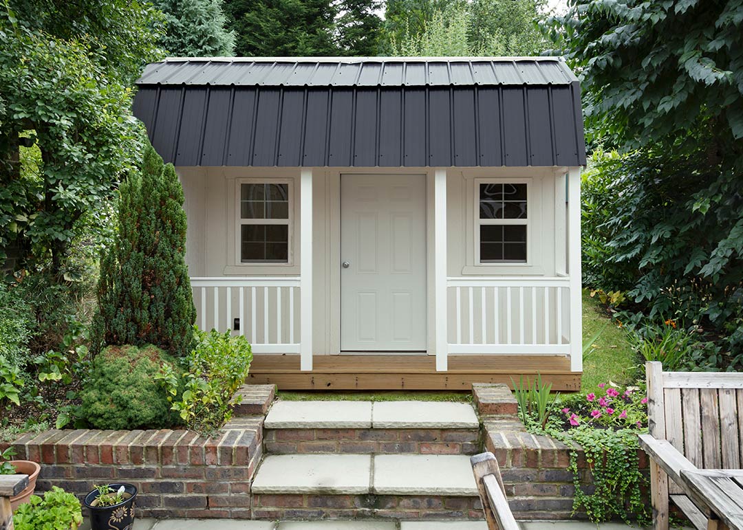 Tiny home with porch and metal roof.