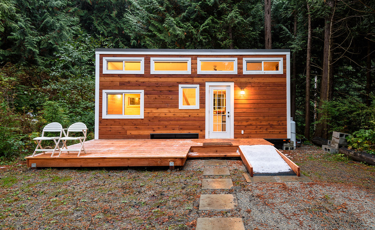 Wood tiny home in the woods on shedsforsale.com